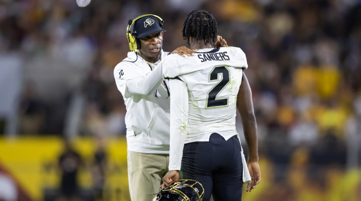 Deion Sanders speaks to his son, Colorado quarterback Shedeur Sanders during a game.